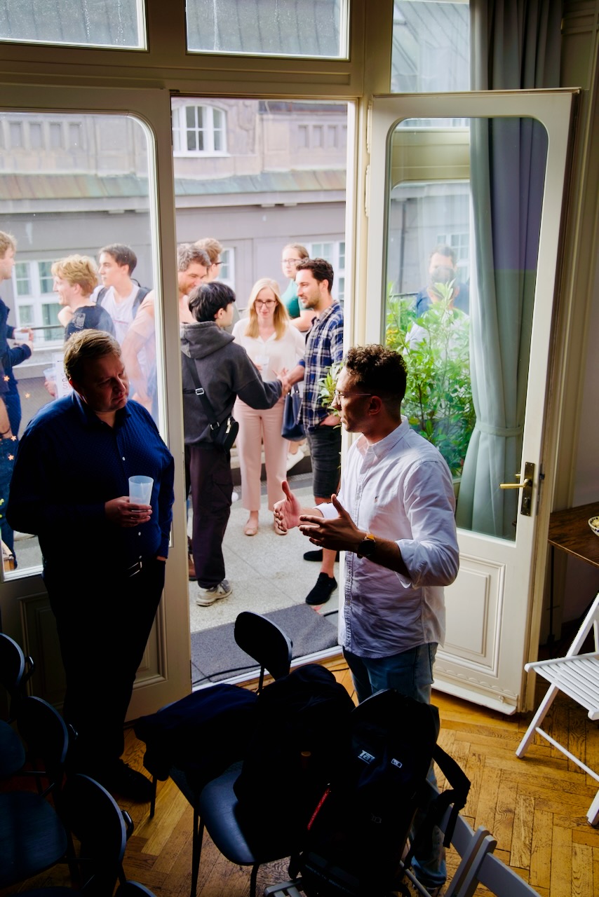 Networking through the open balcony doors before the talk