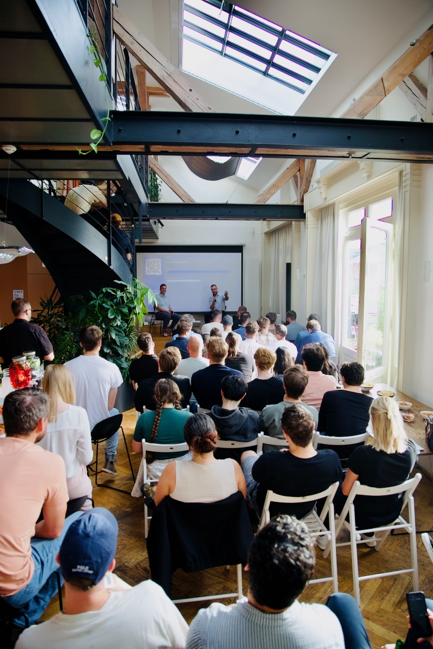 Full house — the audience seated in the Apify loft, skylight overhead